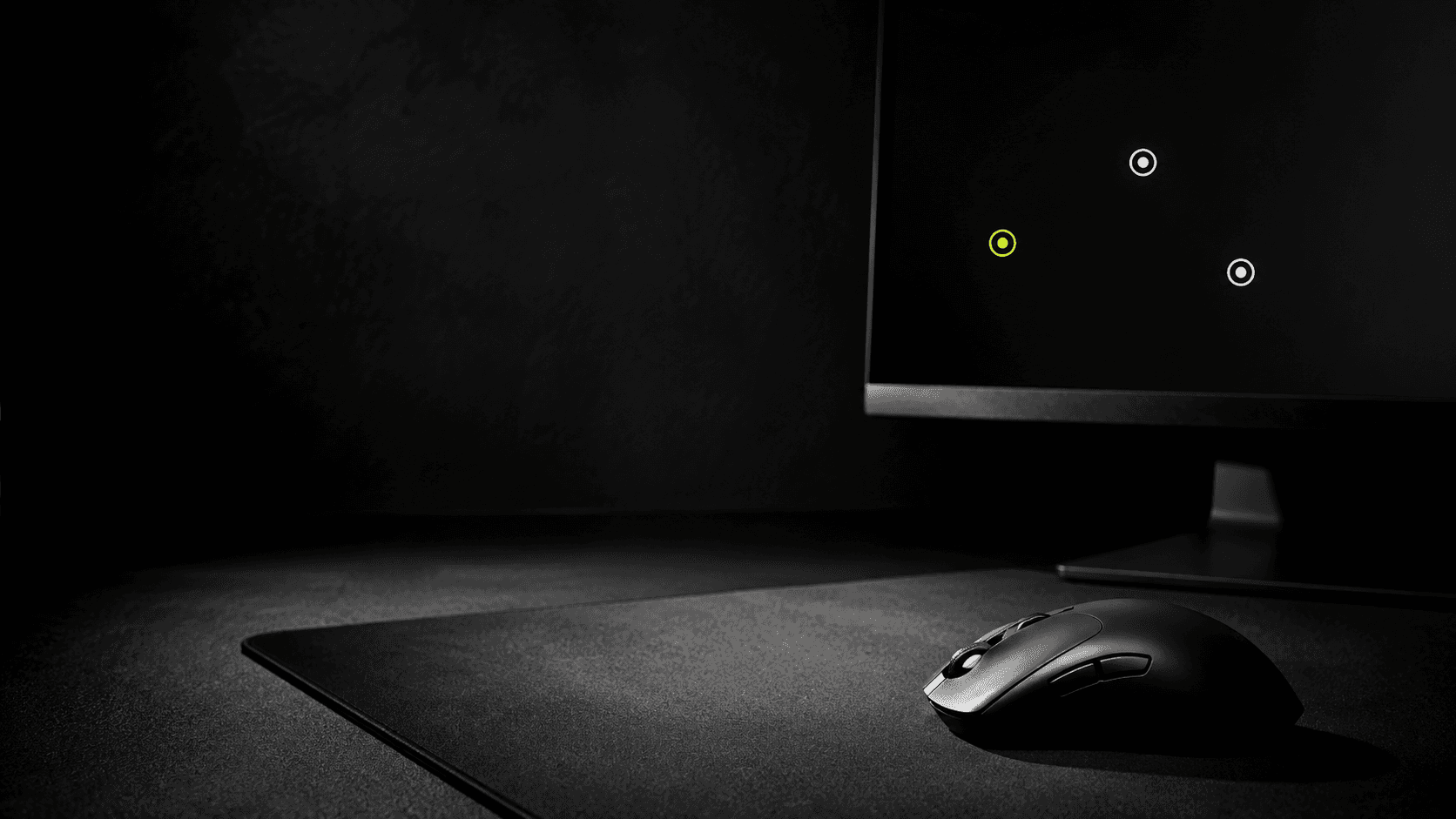 A precision gaming mouse beside three aim targets on a dark monitor